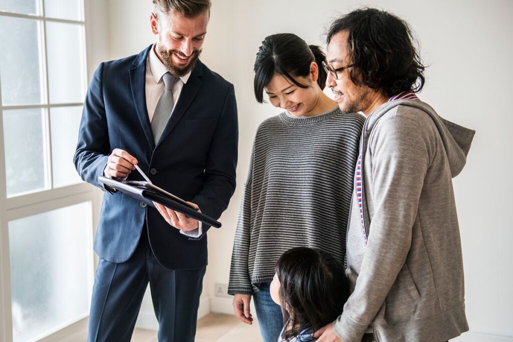 Real estate professional reviewing property documents with a family during a condominium consultation